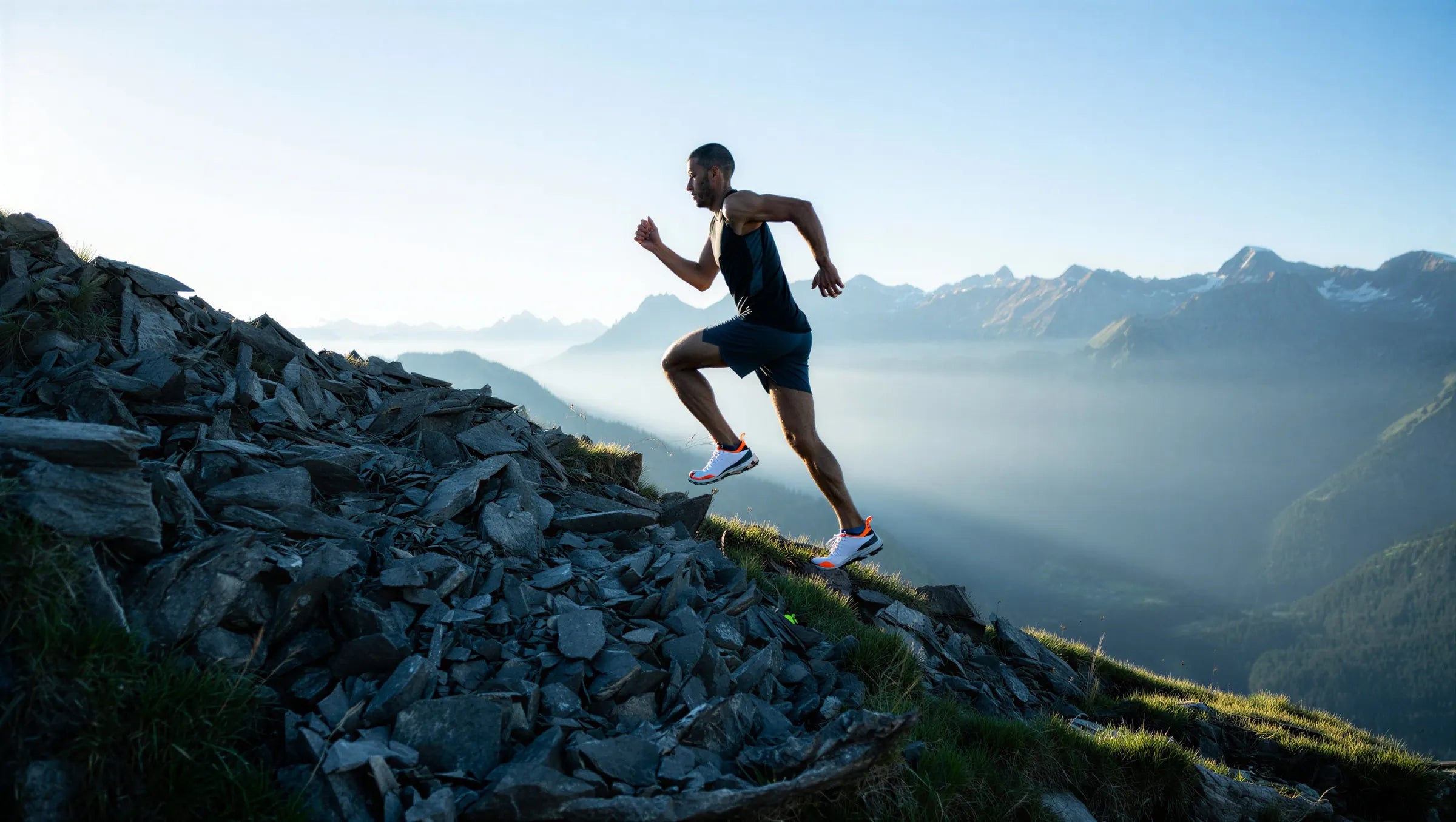 Runner climbing a mountain trail in the morning light